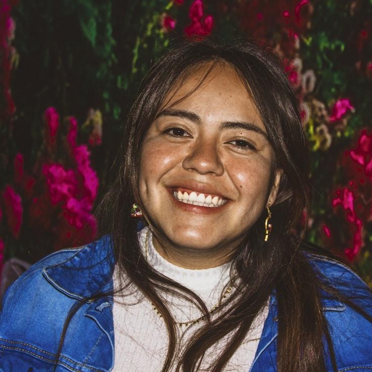 Alexis Chen, Lead Design Curator at GoldenSunsetLedgerWood, reviewing corporate floral arrangements